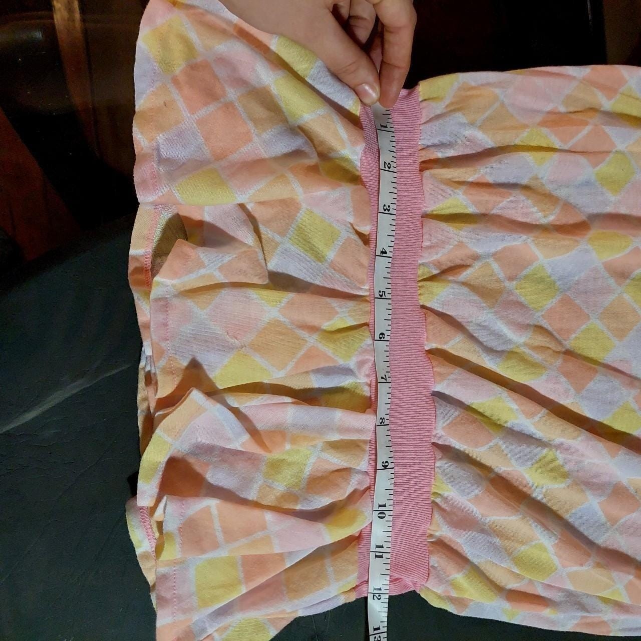 Vintagecpastel pink, purple, yellow, and orange diamond top with a ruffle hem.